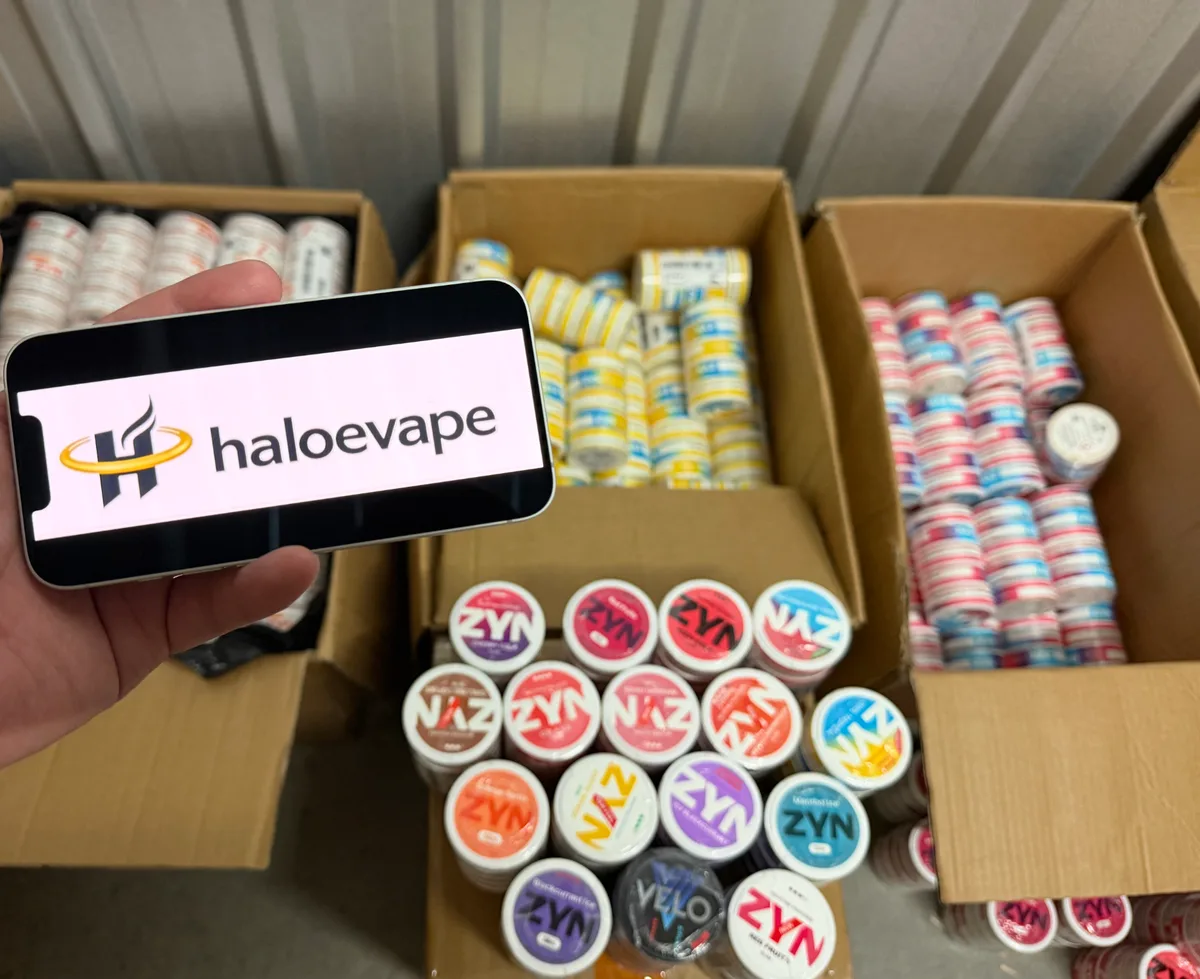 ZYN nicotine pouches stacked in open cartons at Halo E-Vape Australian warehouse with haloevape.com on screen